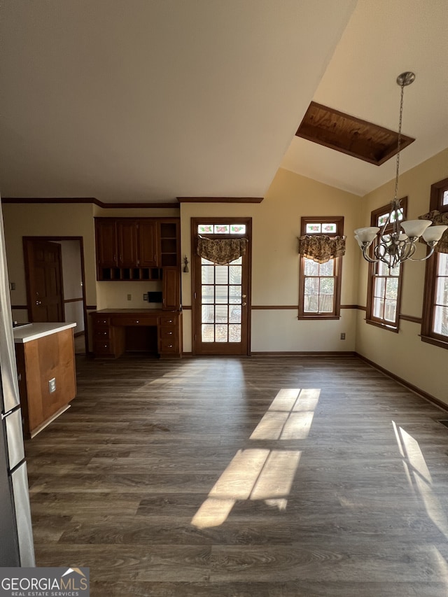 unfurnished living room with dark wood-style floors, vaulted ceiling, a notable chandelier, and baseboards