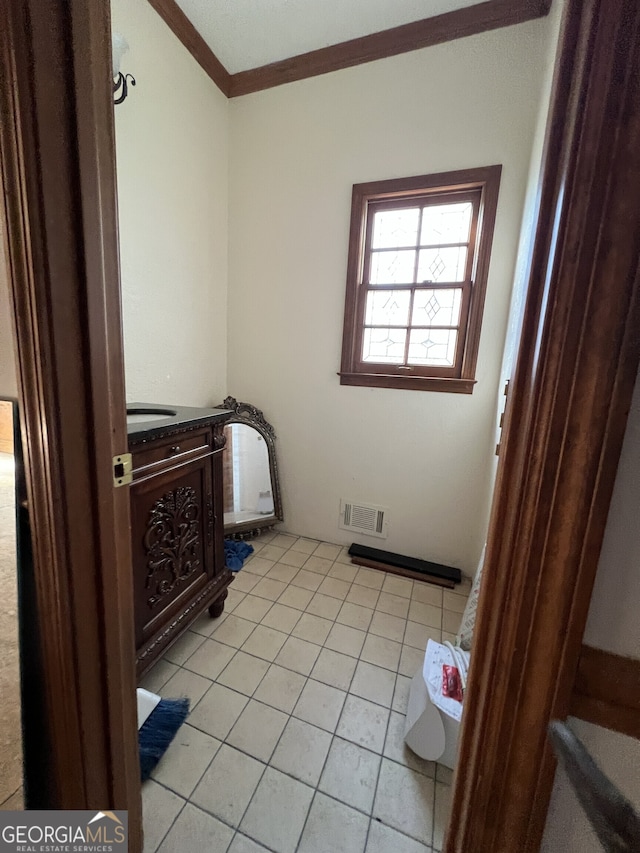 interior space with tile patterned flooring, visible vents, and crown molding