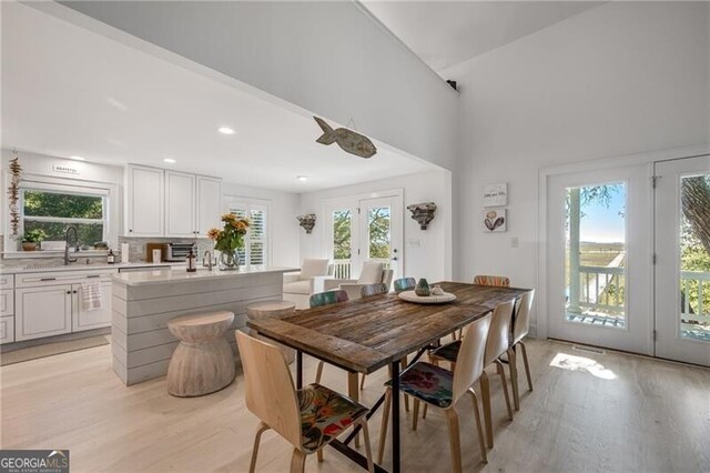 dining area featuring light wood-type flooring, french doors, and plenty of natural light