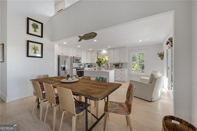 dining space with light wood-style flooring and recessed lighting