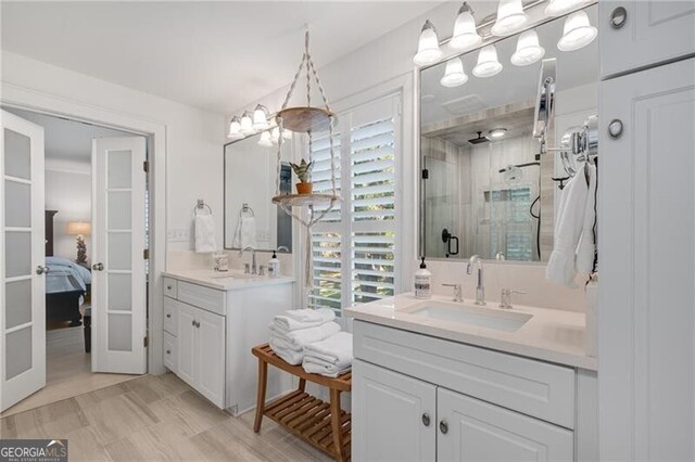 ensuite bathroom with a wealth of natural light, a shower stall, and a sink