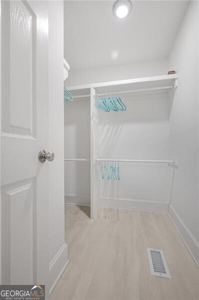 spacious closet featuring visible vents and light wood-style flooring