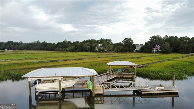 view of dock featuring a rural view and a water view