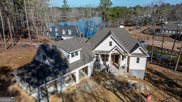 view of front of property featuring a shingled roof and a water view