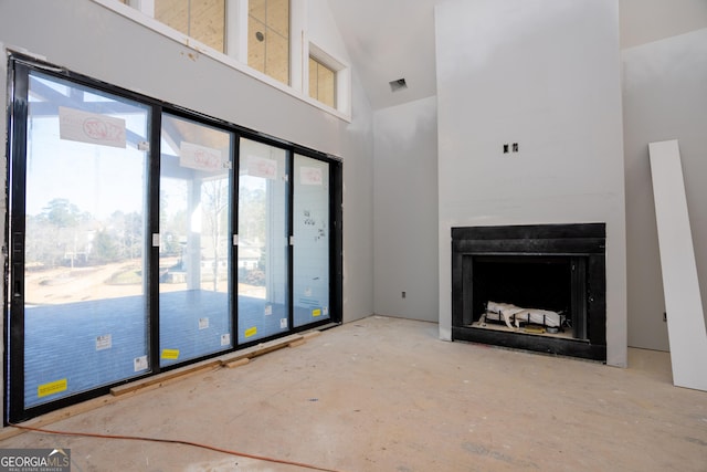 unfurnished living room featuring visible vents, a fireplace, and high vaulted ceiling