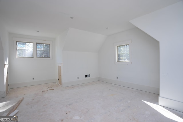 additional living space with vaulted ceiling, a wealth of natural light, and baseboards