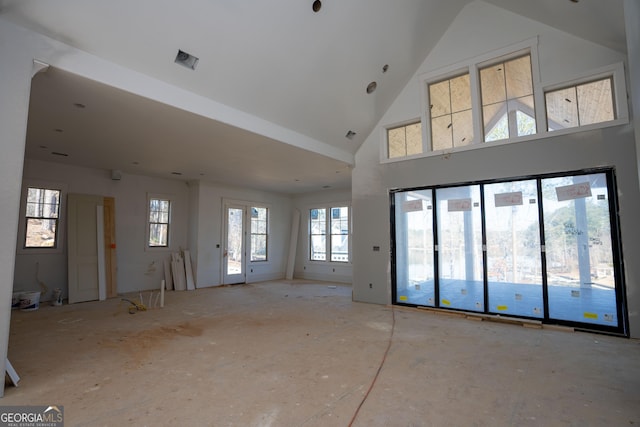 unfurnished living room with high vaulted ceiling