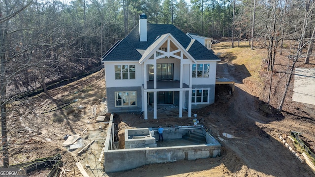 view of front of home with a shingled roof and a chimney