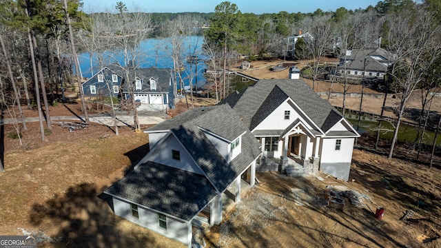 view of front of home featuring a water view and roof with shingles