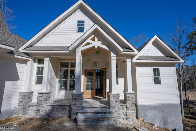 view of front facade featuring a shingled roof and a porch