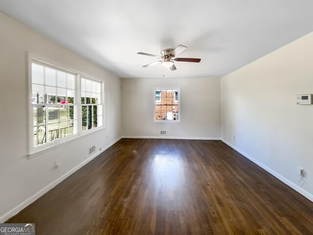 spare room with dark wood-style floors, ceiling fan, and baseboards