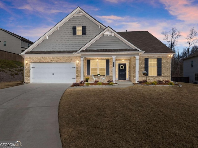 craftsman-style house featuring a front lawn, concrete driveway, and brick siding