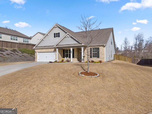 view of front of house featuring driveway, brick siding, a front yard, and fence