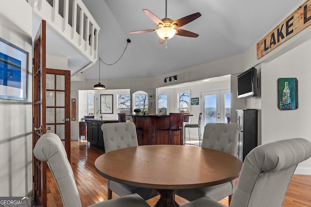 dining space with french doors, a ceiling fan, baseboards, and light wood-style floors