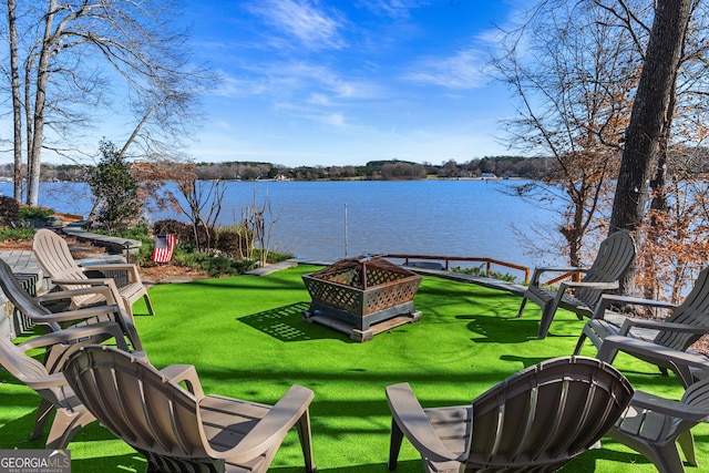 view of yard with an outdoor fire pit and a water view
