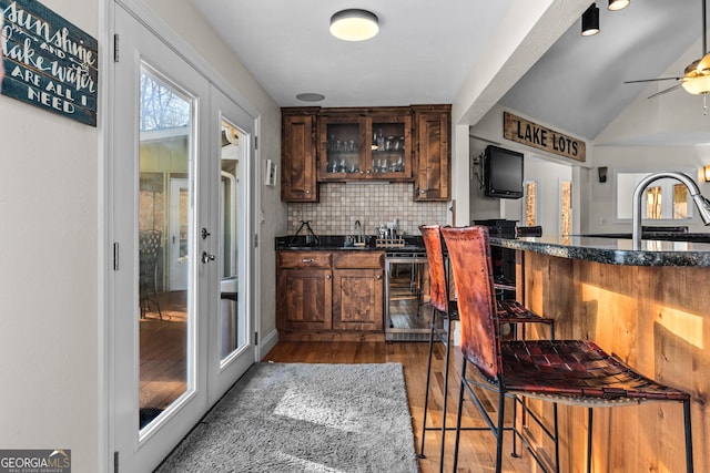 bar with wood finished floors, wine cooler, a ceiling fan, tasteful backsplash, and a sink