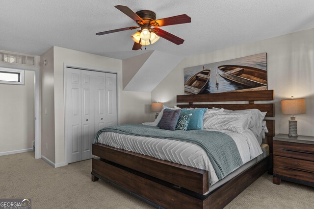 bedroom with a closet, a textured ceiling, visible vents, baseboards, and light colored carpet