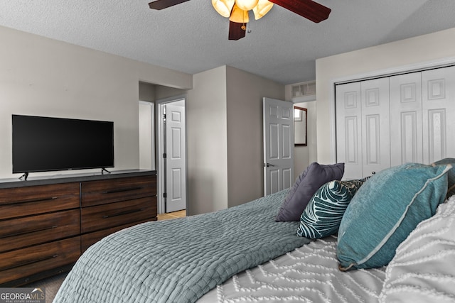 bedroom with a closet, ceiling fan, and a textured ceiling