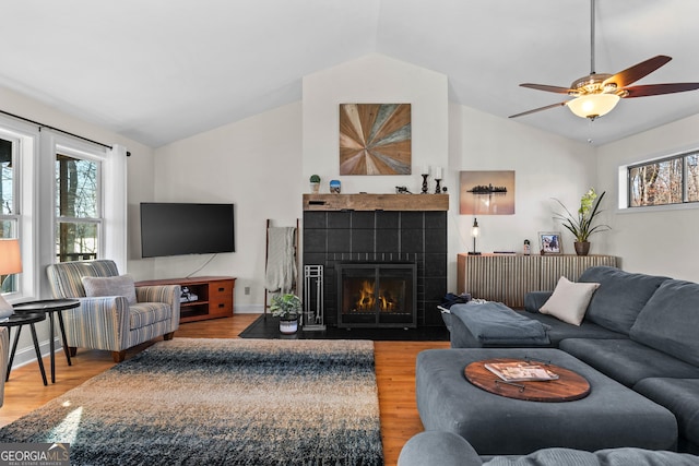 living room with a ceiling fan, lofted ceiling, and light wood-type flooring