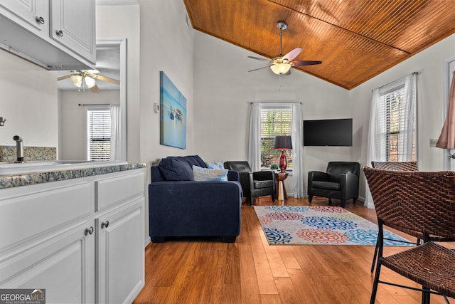 living room with wood ceiling, light wood-style flooring, a healthy amount of sunlight, and a ceiling fan
