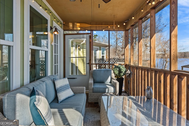 sunroom featuring a ceiling fan and an outdoor living space