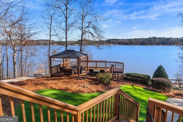 wooden terrace featuring a water view and a gazebo