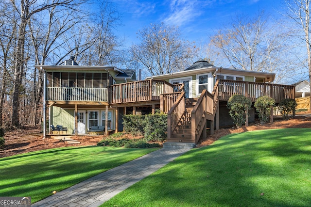 rear view of property with a sunroom, a wooden deck, stairs, and a yard