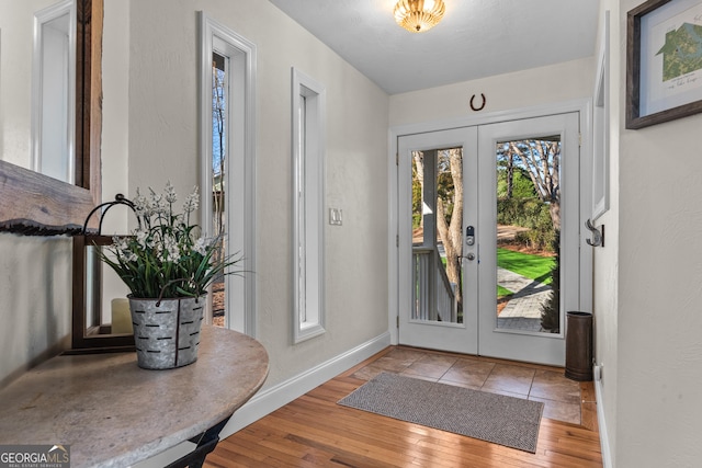 entrance foyer featuring baseboards, french doors, and hardwood / wood-style flooring