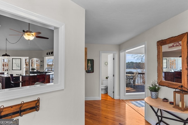 corridor featuring baseboards and wood finished floors