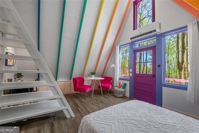 bedroom with lofted ceiling, a wall mounted air conditioner, and wood finished floors