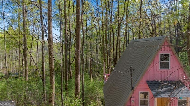 exterior space featuring a forest view, an outdoor structure, and a barn