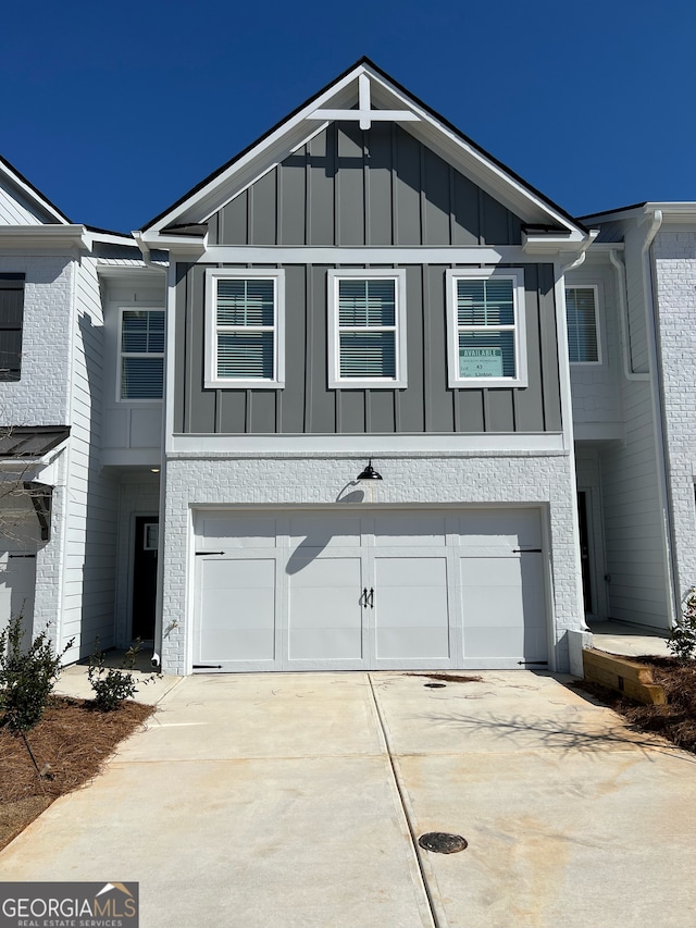 view of front of property featuring driveway, board and batten siding, and an attached garage