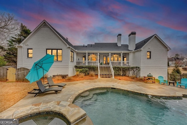 rear view of property with fence, stairs, a fenced in pool, a chimney, and a patio area