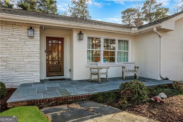 doorway to property with brick siding