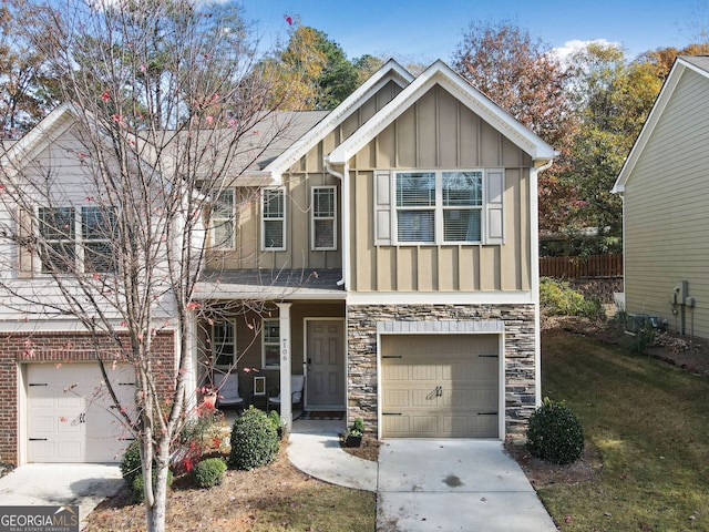 view of front of house with concrete driveway, an attached garage, board and batten siding, stone siding, and a front lawn