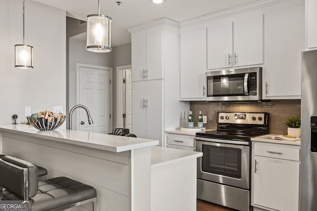 kitchen with stainless steel appliances, decorative light fixtures, and white cabinets