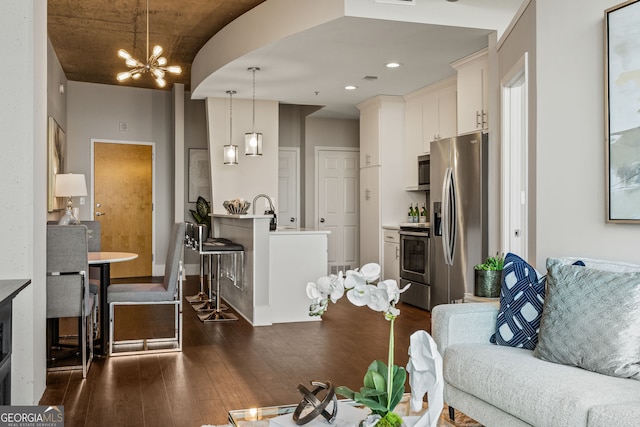 living area featuring a notable chandelier, visible vents, and dark wood-type flooring