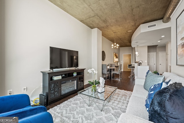 living area featuring a chandelier, dark wood finished floors, and visible vents