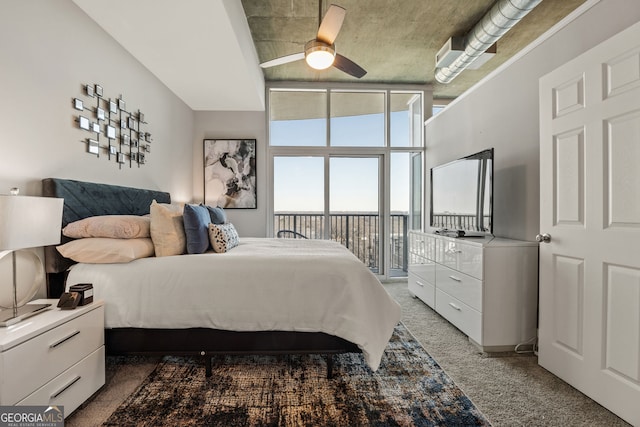 bedroom featuring dark colored carpet, a wall of windows, a ceiling fan, and access to exterior