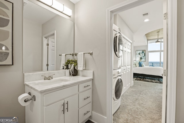 ensuite bathroom with ensuite bathroom, visible vents, vanity, and stacked washer / drying machine