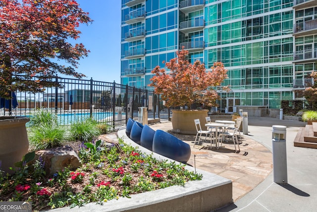 view of property's community with fence and a patio