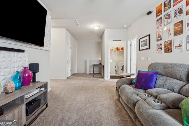 carpeted living room featuring separate washer and dryer, attic access, and baseboards