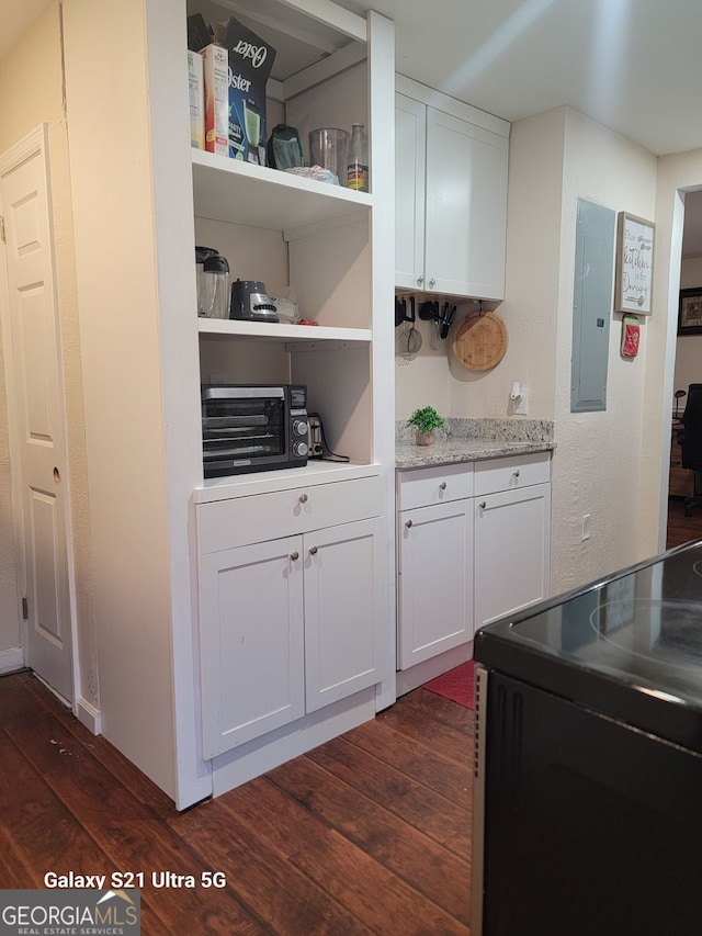 interior space with black electric range, electric panel, dark wood-style flooring, and a toaster