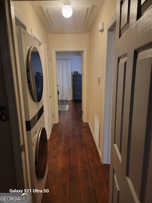 2335 Boulder Rd SE, Atlanta, GA 30316 - clothes washing area with attic access, visible vents, stacked washer and clothes dryer, dark wood-type flooring, and laundry area