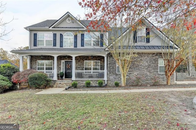 view of front facade featuring stone siding, a front lawn, and a porch