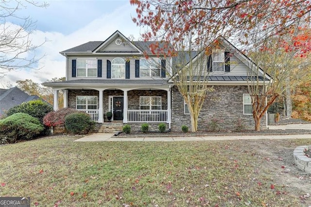 view of front of property with covered porch, stone siding, and a front lawn