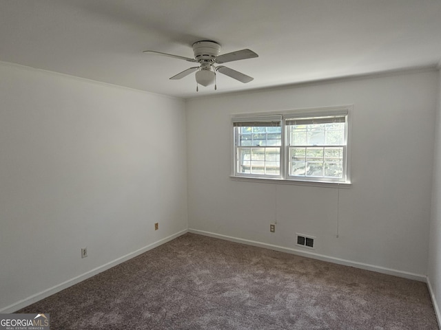 carpeted empty room featuring baseboards, visible vents, and a ceiling fan