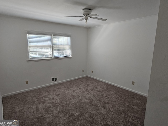 unfurnished room with a ceiling fan, dark carpet, visible vents, and baseboards