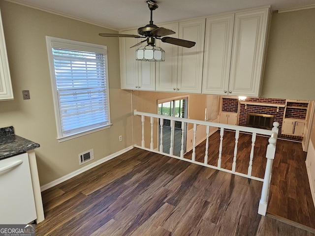 dining room with dark wood-type flooring, a brick fireplace, visible vents, and baseboards