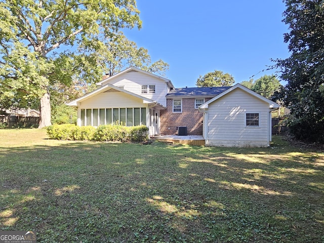 view of front of house with brick siding, a front lawn, fence, and a sunroom